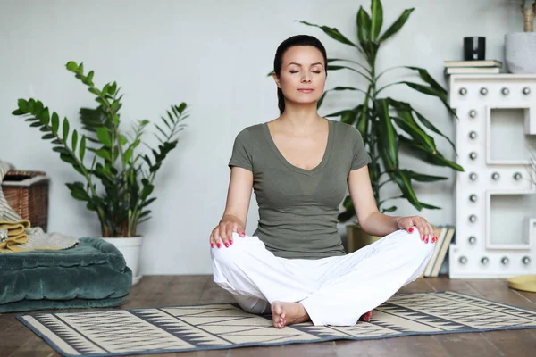 Kvinde Laver Yoga Derhjemme - Stock-foto