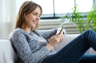 Evde cep telefonu kullanan güzel bir kadın.