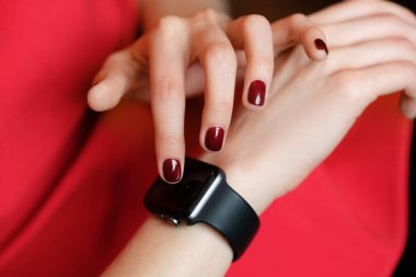 Woman with manicure using modern watch on her hand