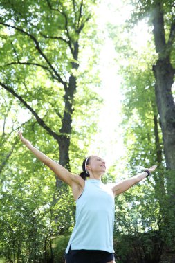 Spor ve sağlıklı yaşam tarzı kavramı. Parkta çalışan genç bir kadın.