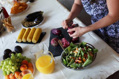 female hand preparing salad and peeling onions