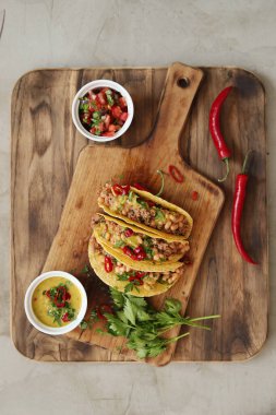 Delicious tacos on the wooden cutting board