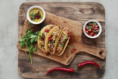 Delicious tacos on the wooden cutting board