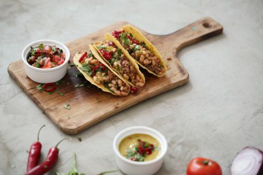 Delicious tacos on the wooden cutting board