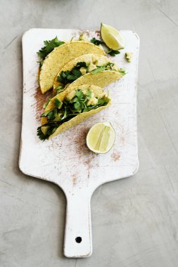 Delicious tacos on the white cutting board