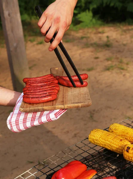 Corn Cobs Grill Mle Hand Holding Prepared Sausages Wooden Board — Φωτογραφία Αρχείου