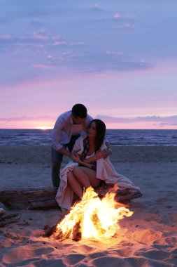 Beautiful couple near bonfire on the beach
