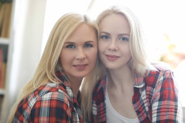 tender image of mother and daughter posing at home