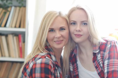 tender image of mother and daughter posing at home
