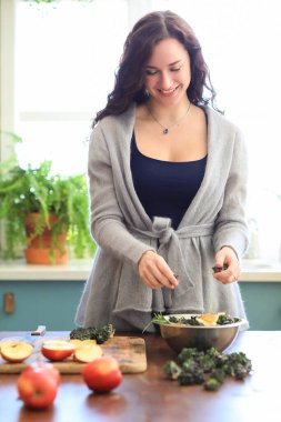 Cute girl is making herself a breakfast in the morning