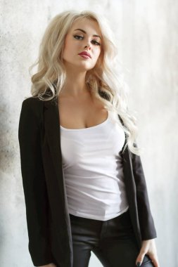 Beautiful woman posing by the wall