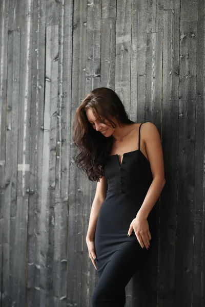 Ahşap Duvarda Siyah Elbiseli Bir Kadın — Stok fotoğraf