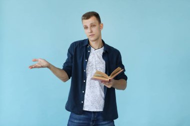 Mavi arka planda kitabı olan yakışıklı bir adam.