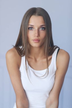 Beyaz gömlekli kadın evde poz veriyor.