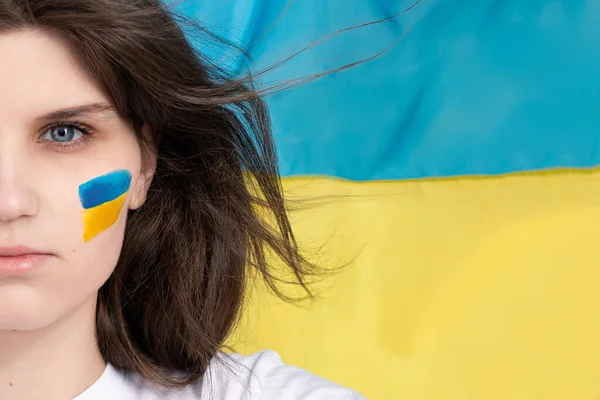 Yanağında mavi ve sarı Ukrayna bayrağı olan kadın yüzü. Ukrayna 'daki savaşı durdurun. Metnin için boşluk, kopyala alanı, afiş