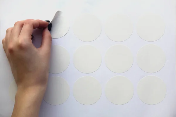 Una Mano Femminile Pulita Stacca Adesivo Bianco Rotondo Della Rifilatura — Foto Stock