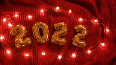 Kırmızı örülmüş, rahat bir ekose kumaş ve Noel ışıklarında 2022 numara..