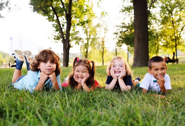 Anaokulu çocukları parkta çimlerin üzerinde oynuyorlar. — Stok fotoğraf