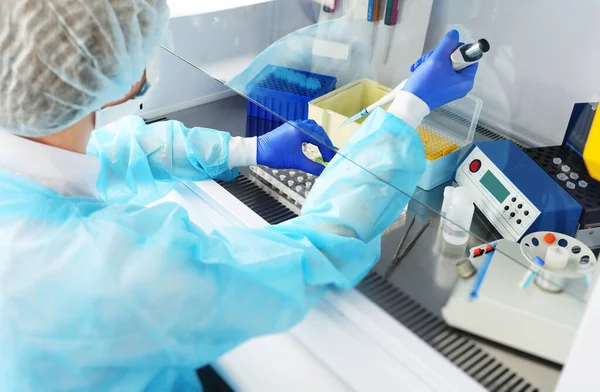 Oficer medyczny laboratorium PCR przeprowadza badania trzymając dozownik w rękach. — Zdjęcie stockowe