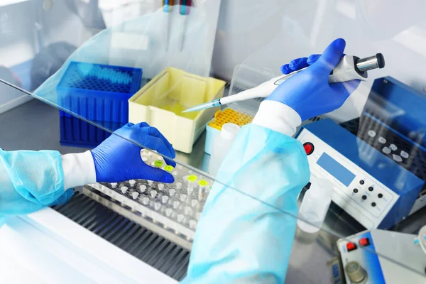Oficer medyczny laboratorium PCR przeprowadza badania trzymając dozownik w rękach. — Zdjęcie stockowe