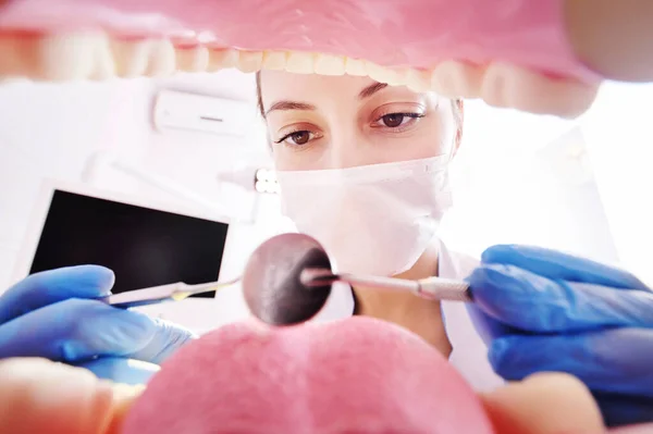 Bastante joven dentista mujer examina los dientes de los pacientes. Vista desde el interior de la mandíbula. — Foto de Stock