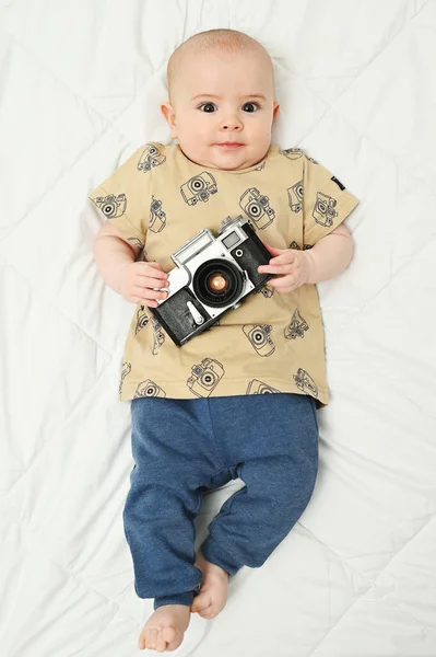 Bébé avec une caméra vintage sur fond blanc — Photo