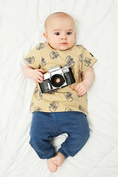 Vauva, jolla on vuosikerta kamera valkoisella taustalla — kuvapankkivalokuva