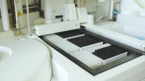 Analisador com recipientes com tubos de ensaio em close-up num laboratório de PCR — Vídeo de Stock