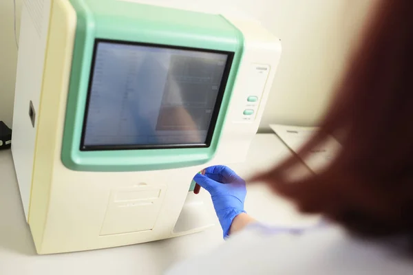 Лаборант осматривает образец крови в анализаторе в современной микробиологической клинике. — стоковое фото