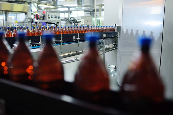 Bir bira fabrikasının arka planındaki taşıma bandındaki plastik bira şişeleri. — Stok fotoğraf