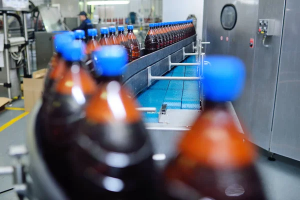Plastikowe butelki piwa na przenośniku taśmowym w tle browaru — Zdjęcie stockowe