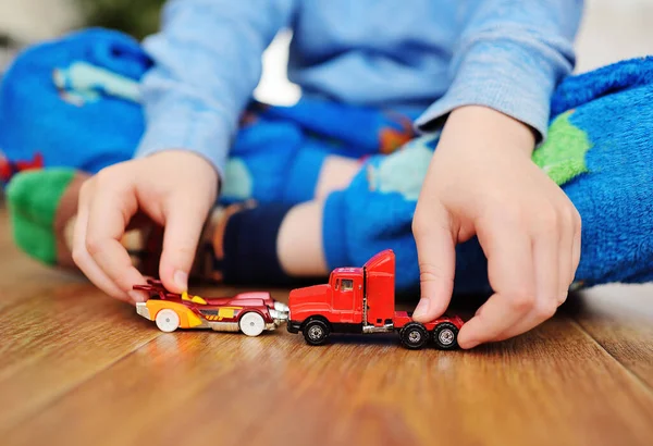 Hands of a small boy close-up with toy cars — Stock Photo, Image