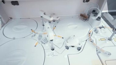 Modern bir mikrobiyoloji laboratuvarının kadın çalışanı kan örneklerini bir biyokimya laboratuvarına kan analizcisi olarak gönderir..