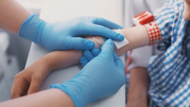 Arts of verpleegkundige neemt bloed uit een ader in een kind van een jongen. Bloedchemie — Stockvideo