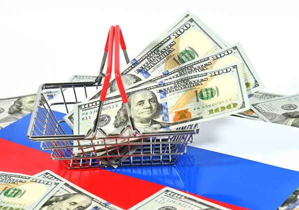 Корзина для супермаркета с долларами США на фоне российского триколорного флага. — стоковое фото