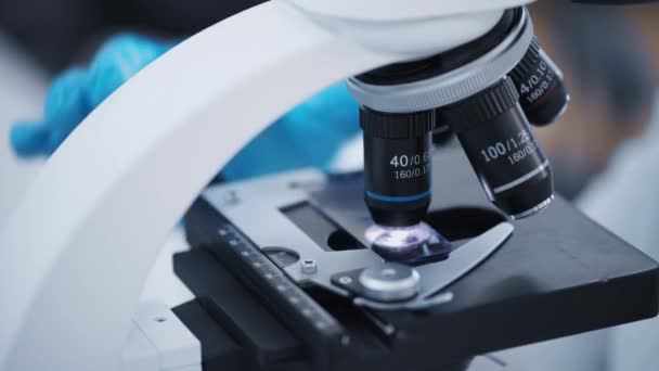 Researcher examines samples of a modern electron diode microscope close-up in a modern biochemical laboratory. — Stockvideo