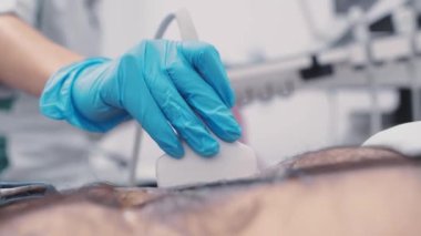 nurse or doctor doing abdominal ultrasound to a man in a modern clinic