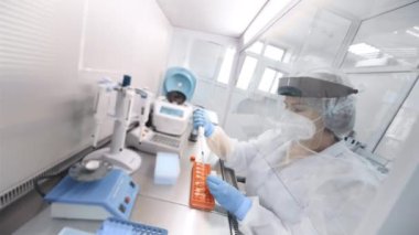 Bir kadın bilim adamı modern bir kimya ve bakteri laboratuvarında PCR DNA testleri yapıyor..