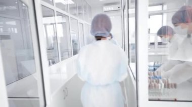 Modern bir biyokimya laboratuvarında çalışan bir grup çalışan ve bilim adamı tıbbi ofislerinde test ve analiz yapıyorlar.