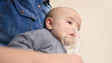 Erkek bebek astım spreyinden ya da nebulizörden nefes alır.