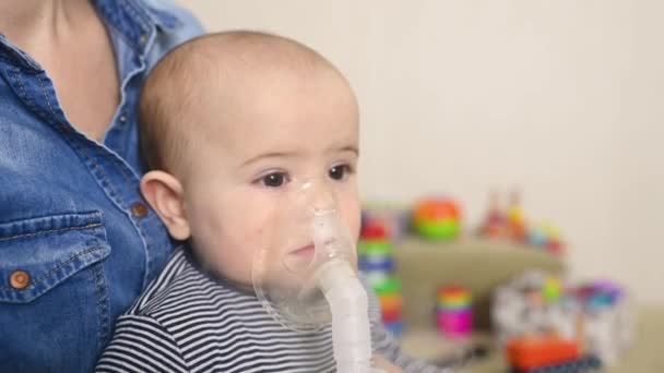 Baby boy breathes through an inhaler or nebulizer — Stockvideo