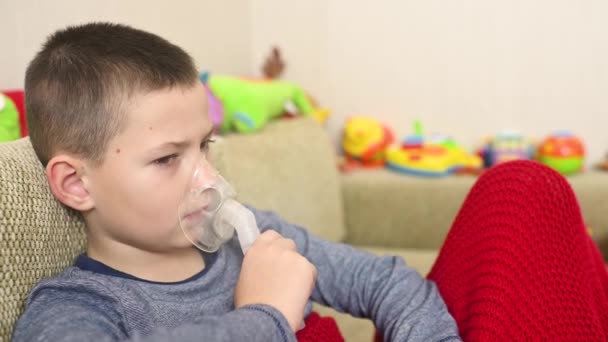 Kind tiener jongen ademt door middel van een inhalator of vernevelaar — Stockvideo