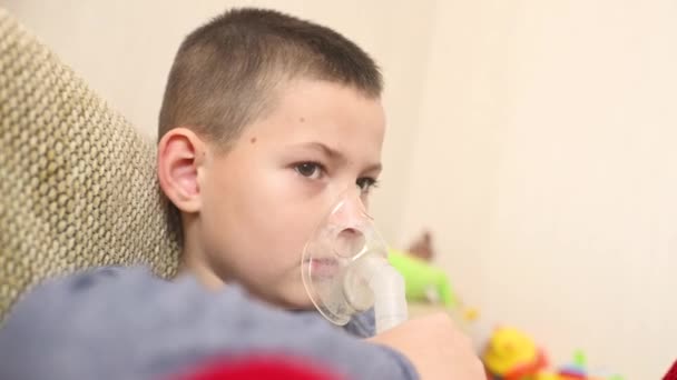 Child teenager boy breathes through an inhaler or nebulizer — Stock video