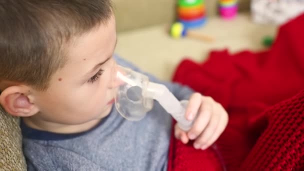 Child teenager boy breathes through an inhaler or nebulizer — ストック動画