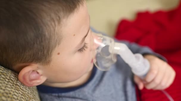 Child teenager boy breathes through an inhaler or nebulizer — Stock Video