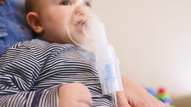 Baby boy breathes through an inhaler or nebulizer — Stock video