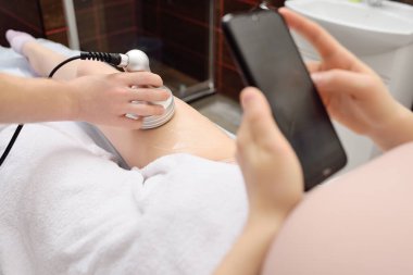 Masör, modern bir kozmetik kliniğinde genç bir kadına dişçilik yapıyor..