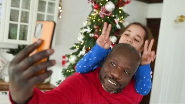 아버지의 어깨에 한어린딸은 비디오 링크를 친척들 의사소통을 하면서 미소를 흔들며 — 비디오