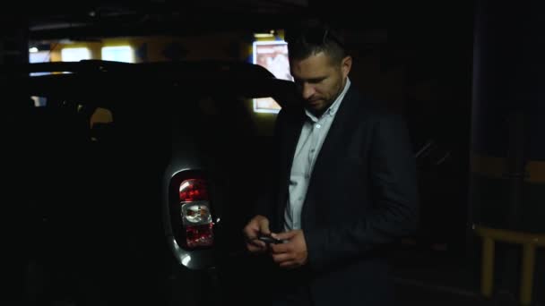 Podnikatel nebo řidič uzamkne své auto pomocí dálkového ovládání na klíčích od auta v podzemním parkovišti — Stock video