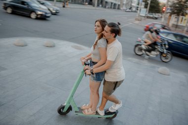 Çiftler güneşli bir günde elektrikli scooter sürerken eğleniyorlar..
